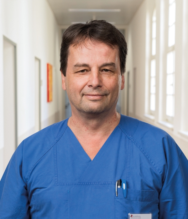 Portrait von Dr. med Jens Schnabel vor Klinikkorridor