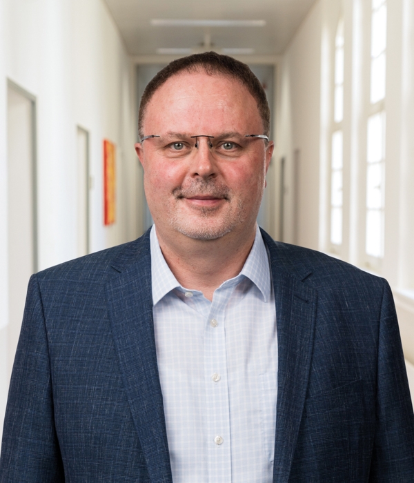 Portrait von Wolfgang Gruner vor Klinikkorridor