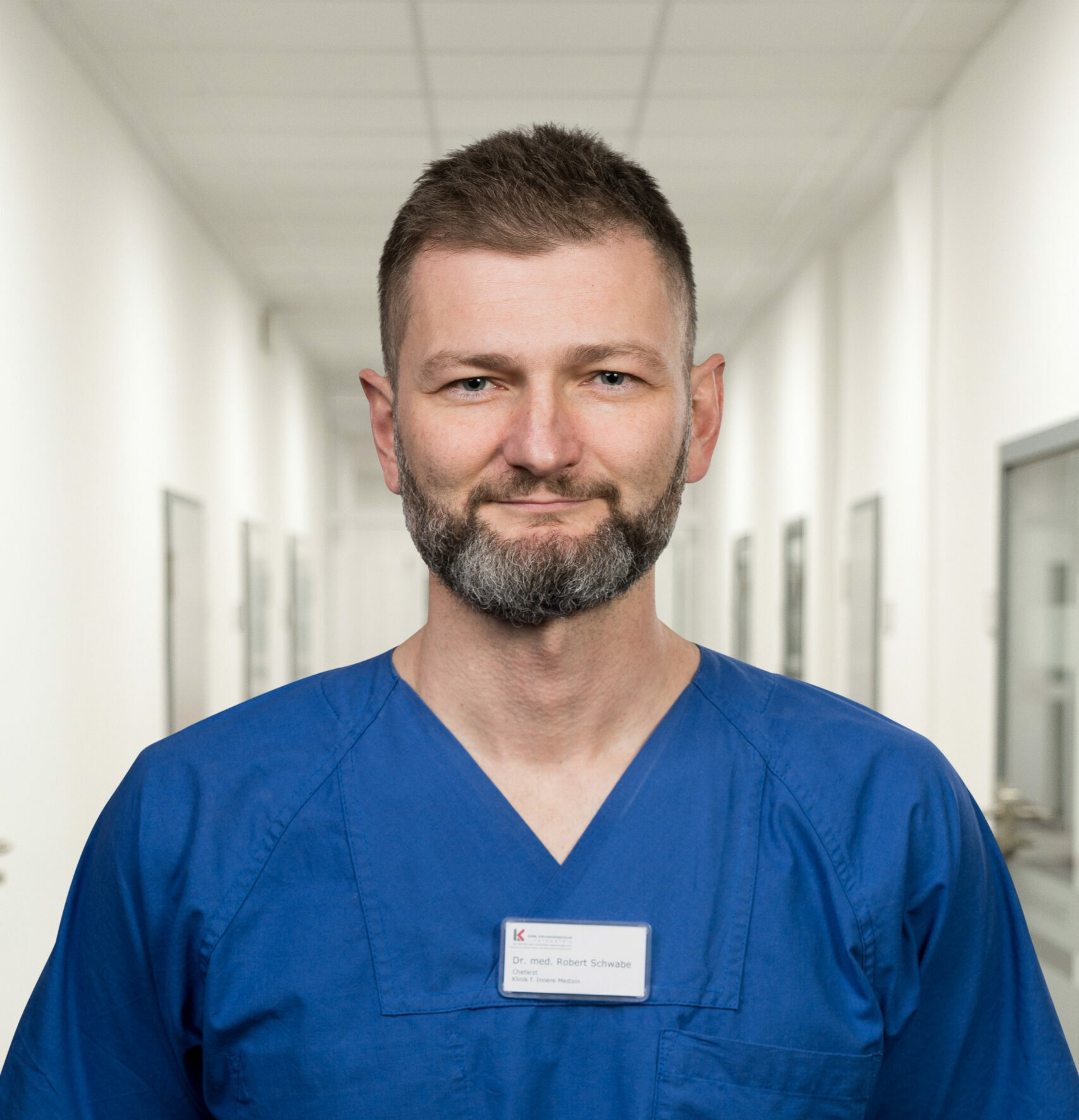 Portrait Dr. med. Robert Schwabe vor Klinikkorridor