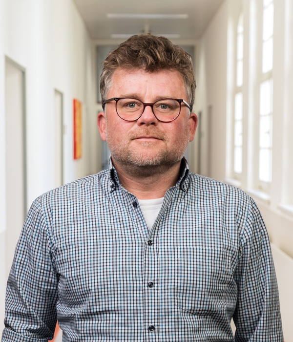 Portrait von Daniel Barth vor Klinikkorridor