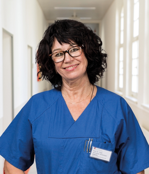 Portrait von Dr. med. Sylvia Schneider-Schönherr vor Klinikkorridor