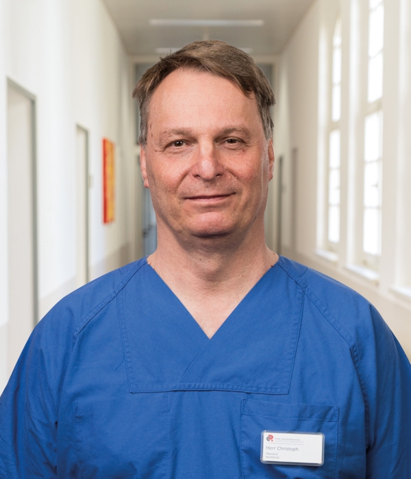 Portrait von Thomas Christoph vor Klinikkorridor